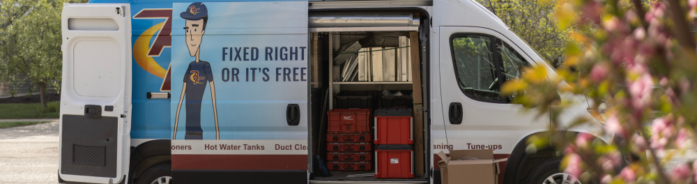 An Action Furnace truck sits outside a home. The door is open showcasing all the equipment the technician needs to complete the job.